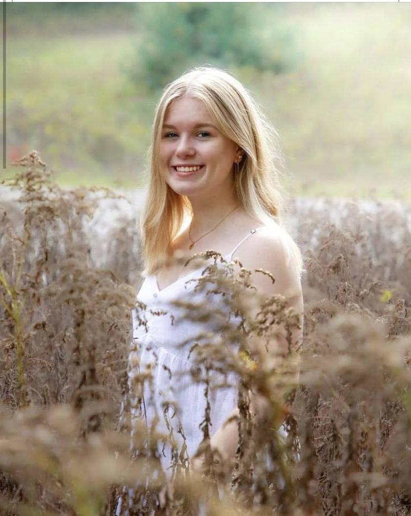 Olivia Darroch in a field wearing a white tank top